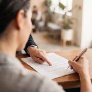 Persona firmando un contrato de matrícula con garantía de aprendizaje en una academia de idiomas