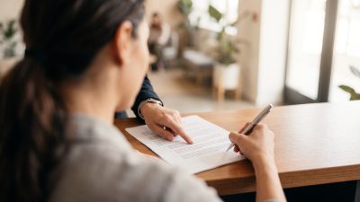 Persona firmando un contrato de matrícula con garantía de aprendizaje en una academia de idiomas