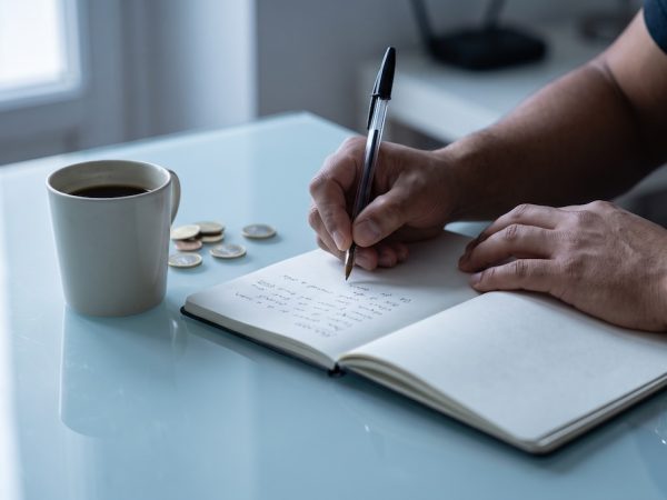 Estudiante escribiendo los números en alemán del 0 al 100 en un cuaderno durante una clase