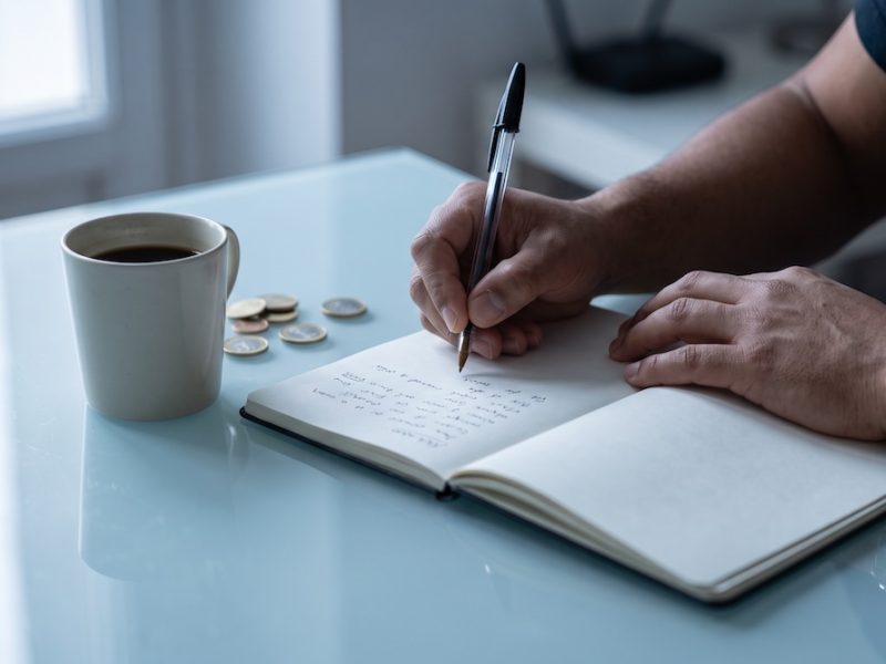 Estudiante escribiendo los números en alemán del 0 al 100 en un cuaderno durante una clase