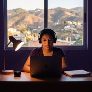 Estudiante hondureña preparando el TOEFL en Honduras con laptop y audífonos