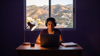 Estudiante hondureña preparando el TOEFL en Honduras con laptop y audífonos