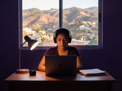 Estudiante hondureña preparando el TOEFL en Honduras con laptop y audífonos